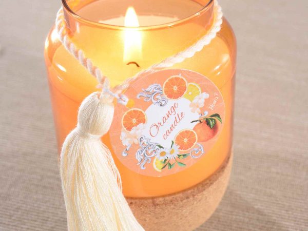 Bougie parfumée Celes’Tea senteur Orange – pot de verre orange avec base liège et pompon – ambiance lumineuse et chaleureuse du salon de thé du Neubourg.